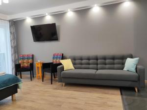 a living room filled with furniture and a couch at Apartamentylove - Apartament Kiliński in Łódź