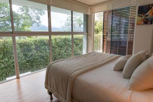 a bedroom with a large bed with large windows at Libertg Hotels Spa in Copacabana