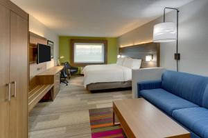 a hotel room with a bed and a couch at Holiday Inn Express - Cincinnati North - Monroe, an IHG Hotel in Monroe