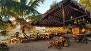 a restaurant on the beach with chairs and palm trees at Cabôco Sonhadô Passeios Náuticos e Pousada in Mundaú +54 photos