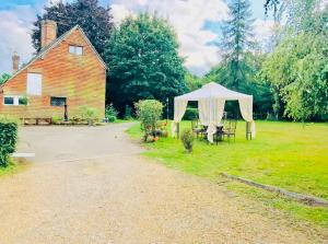 a gazebo in a field next to a barn at Oldlands Farmhouse Gatwick in Horley