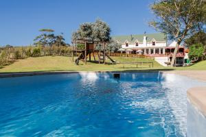 una piscina con parque infantil frente a una casa en Malagas Hotel, en Malgas