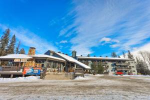 a resort building with snow on the ground at Griz Inn by FantasticStay in Fernie