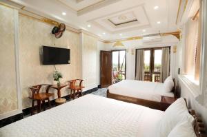 Little Saigon Hostel في تشاو دوك: غرفه فندقيه سريرين وتلفزيون
