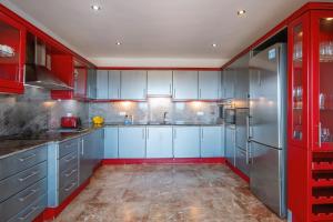 a kitchen with blue and red cabinets and a refrigerator at Villa Suria in Jávea