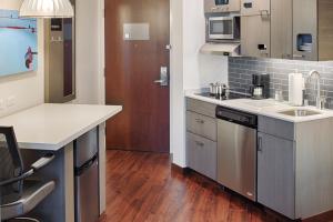 a kitchen with a refrigerator, stove, sink and microwave at Hyatt House Seattle Downtown in Seattle