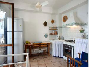 cocina con nevera y mesa. en Casa Marettimo en Marettimo