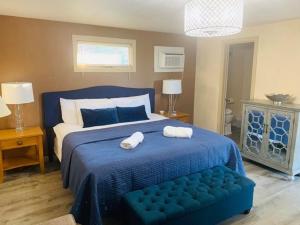 a bedroom with a blue bed with two towels on it at Starlight Lodge at Rockport Harbor in Rockport