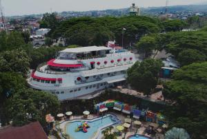 un bateau de croisière amarré à côté d'une piscine dans l'établissement Kapal Garden Hotel Malang, à Malang