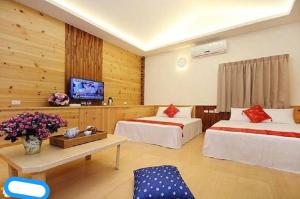 une chambre d'hôtel avec deux lits et une télévision dans l'établissement Yun Cui Leisure B&B, à Lugu