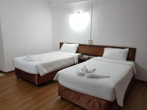 Postel nebo postele na pokoji v ubytování Wiangwalee Hotel