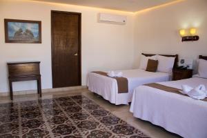 a hotel room with two beds and a door at El Navegante in Campeche