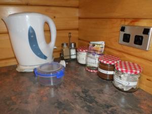 encimera de cocina con jarras y cafetera en Mirabell Chalets, en Alexandra