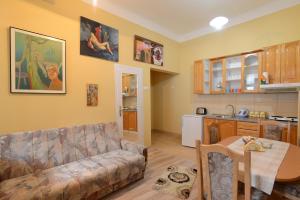 a living room with a couch and a table and a kitchen at Sobe Zlatna Greda Motorcycle friendly in Novi Sad