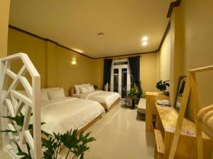 um quarto de hotel com duas camas e uma mesa em CozyNook Boutique Apartments - 3 thang 2 Street em Da Lat