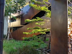 a wooden staircase in front of a building with plants at Wonderwall Hotel in Chiang Mai