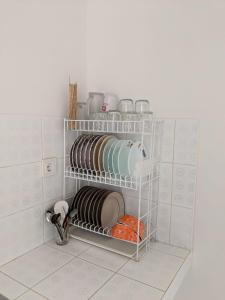 a shelf with plates and other dishes in a kitchen at Nirwana Highland @ sentul City in Bogor +61 photos