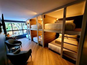 Pokój z łóżkami piętrowymi, biurkiem i krzesłami w obiekcie The Blue Hotel Bondi w mieście Sydney