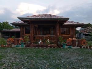 a log cabin with a wrap around porch at Vievan's transient house in Alaminos