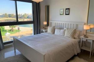 a bedroom with a large bed and a large window at Fairways luxury pool villa in Ras al Khaimah