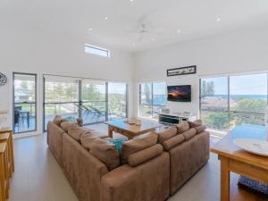 a living room with a couch and a table at Bimbadeen Penthouse in Yamba