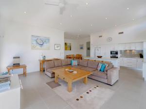 a living room with a couch and a table at Bimbadeen Penthouse in Yamba