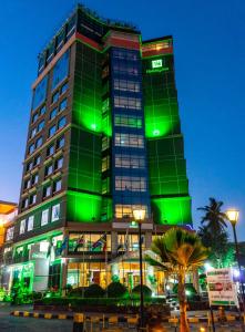 un bâtiment avec des lumières vertes au-dessus dans l'établissement Holiday Inn Dar Es Salaam, an IHG Hotel, à Dar es Salaam