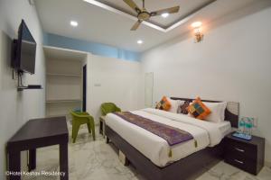 a bedroom with a bed and a desk and a television at Hotel Keshav Residency in Chittaurgarh