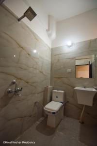 a bathroom with a toilet and a sink at Hotel Keshav Residency in Chittaurgarh