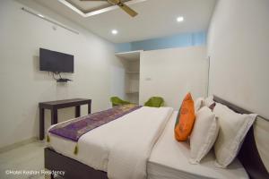 a bedroom with a bed and a tv on the wall at Hotel Keshav Residency in Chittaurgarh