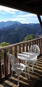 仁愛鄉的住宿－維多利亞山莊，观景甲板上配有两把椅子和一张桌子