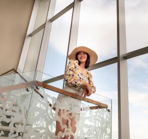 Eine Frau mit einem Hut, die in einer Glaskiste steht. in der Unterkunft Jasmine Resort Bangkok in Bangkok