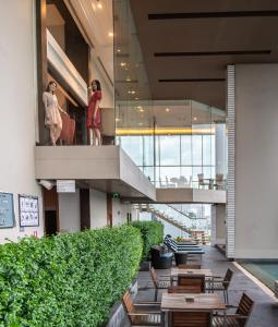 a lobby of a building with tables and a staircase at Jasmine Resort Bangkok in Bangkok