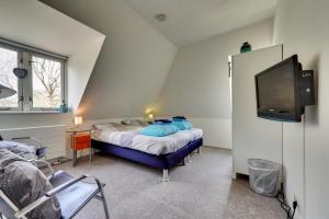 Habitación pequeña con 2 camas y TV. en Hotel Frederiksoord, en Frederiksoord