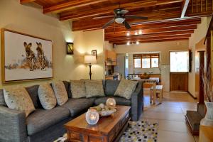 ein Wohnzimmer mit einem Sofa und einem Tisch in der Unterkunft Cambalala - Luxury Units - in Kruger Park Lodge - Serviced Daily, Free Wi-Fi in Hazyview