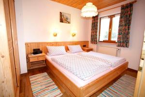sypialnia z drewnianym łóżkiem w pokoju w obiekcie Haus Krautloider w mieście Reit im Winkl