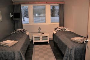 a small room with two beds and a window at Kipinä Lomat - Majatalo Kipinä in Sotkamo