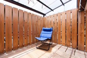 einem blauen Stuhl auf einer Terrasse mit einem Zaun in der Unterkunft 伏見稲荷ハウス Fushimi Inari House in Kyoto