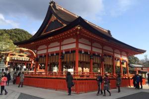 ein großes Gebäude mit Leuten, die davor stehen in der Unterkunft 伏見稲荷ハウス Fushimi Inari House in Kyoto