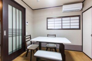 ein Raum mit einem Tisch und Stühlen und einem Fenster in der Unterkunft 伏見稲荷ハウス Fushimi Inari House in Kyoto