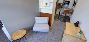 Habitación pequeña con silla blanca y mesa. en Boardinghouse Emden en Emden