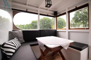 een eetkamer met een tafel en een bank bij HAVEL-Cruiser Hausboot-Flöße mit Stil in Brandenburg an der Havel