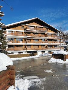 un grand immeuble dans un parking enneigé dans l'établissement CRANS MONTANA LE REGENT APPARTEMENT, à Crans-Montana