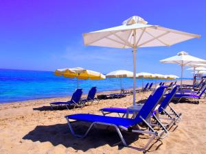 a group of chairs and umbrellas on a beach at Бяла Виста Бийч Апартментс A - Byala Vista Beach Apartments A in Byala