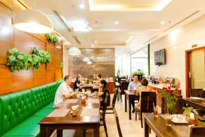 a restaurant with people sitting at tables at White Lotus Saigon Hotel in Ho Chi Minh City