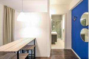 een eetkamer met een tafel en een blauwe muur bij Apartment Vanga in Bolzano +25 foto's
