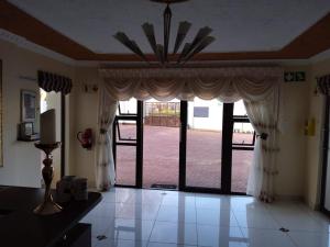 a living room with a large window with curtains at Ecotel OR Tambo Airport in Kempton Park