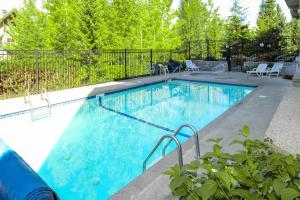 uma piscina com água azul num quintal em Greystone Lodge 314&315 em Whistler