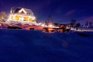 a house with a boat in the snow at night at Góralska Dolina in Bańska