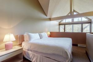 a bedroom with a large white bed and a window at Greystone Lodge 314&315 in Whistler